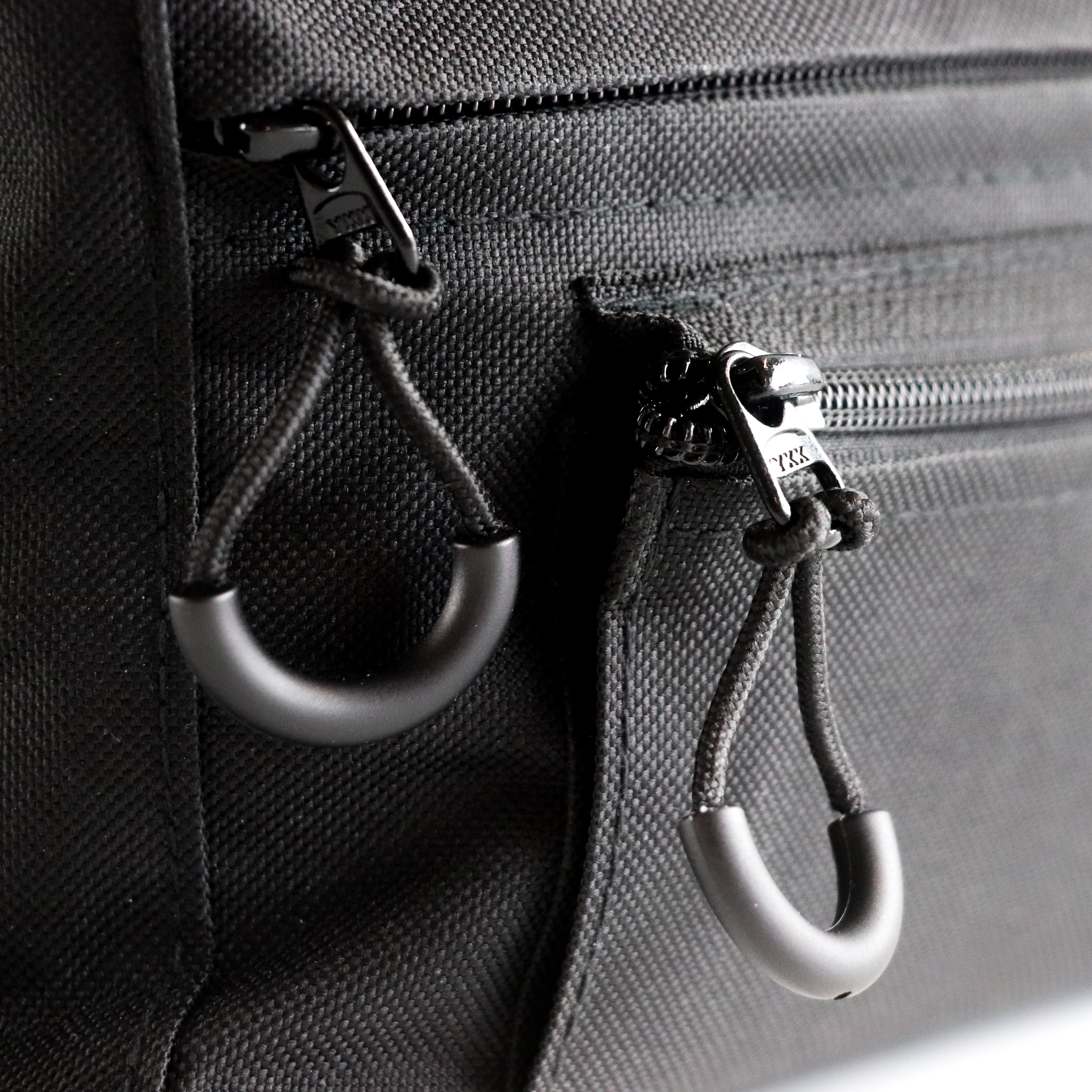 Close-up of a Defiance underchair bag showing the zippers with easy to pull finger loops.