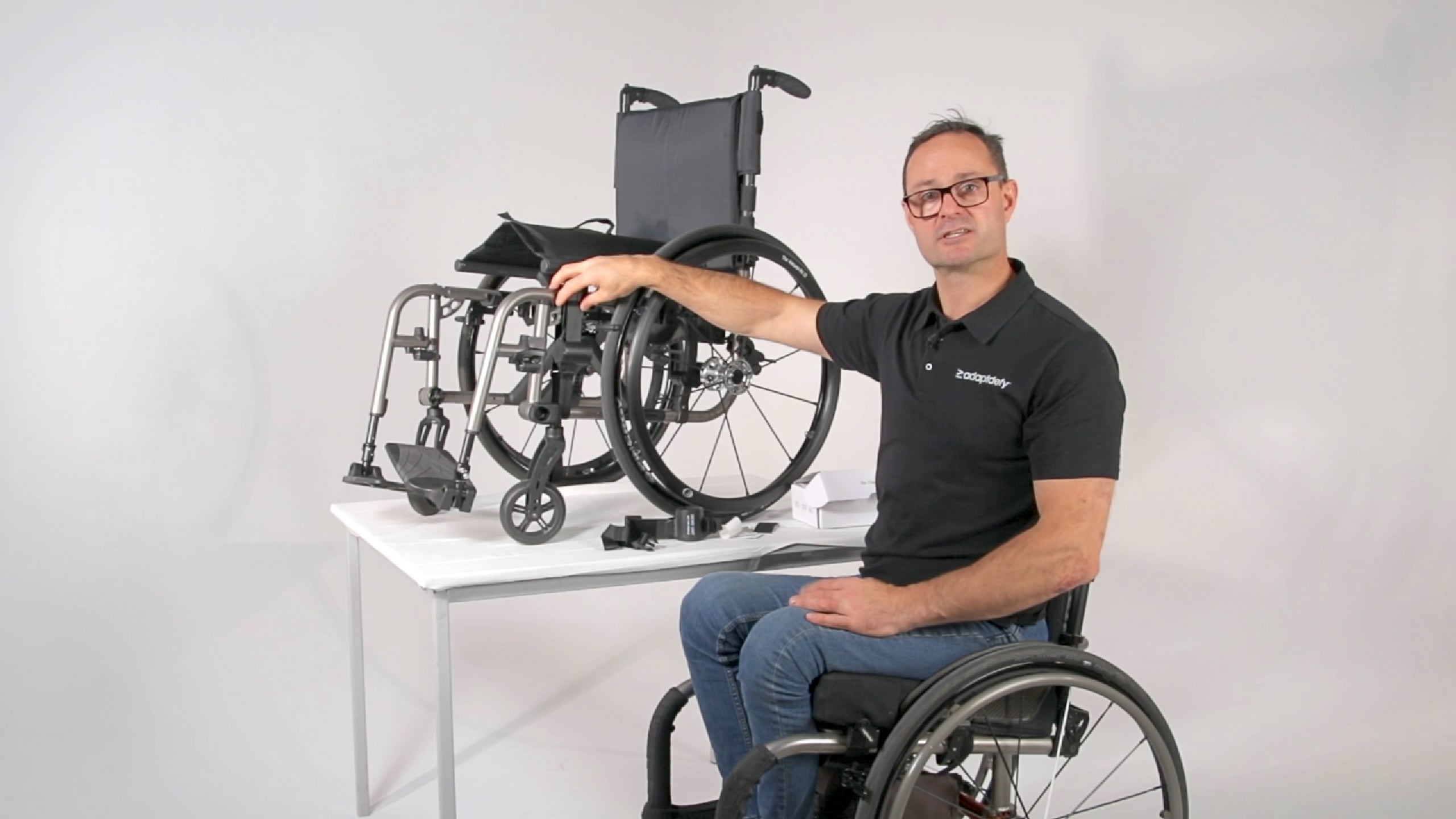 A man in a wheelchair shows you how to install a LapStacker Flex vertically on a dual frame manual folding wheelchair. 